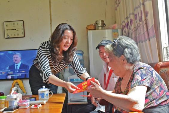 华阳街道办主任徐淑英向老党员送上慰问金.